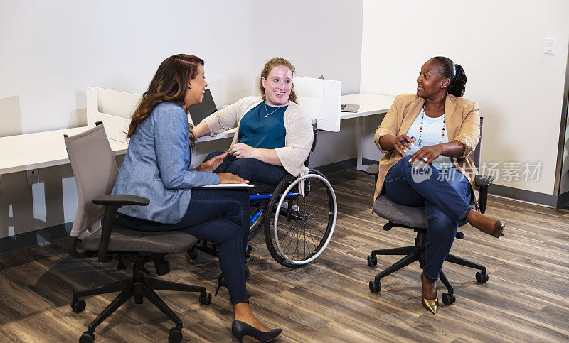 Three businesswomen meeting in office, one in wheelchair